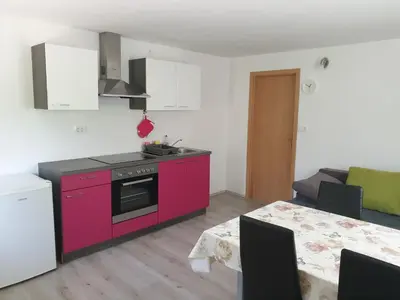 a kitchen with a pink stove and a dining table at Apartma Patricija - Cozy apartments for 2 or 4 people in Tolmin