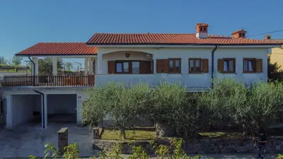 a white house with a red roof at Apartma Tri oljke in Dobrovo