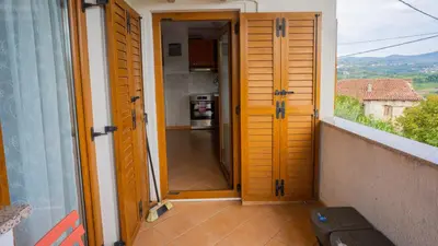 an open door to a balcony with a kitchen at Apartma Tri oljke in Dobrovo