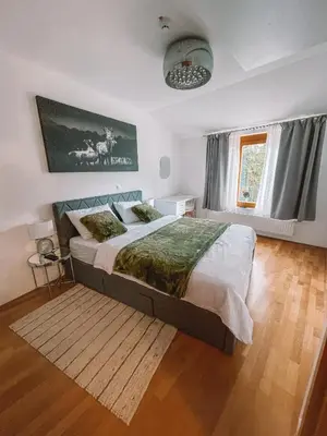 a bedroom with a large bed and a window at Apartma Pohorske terase Brumen Mariborsko Pohorje in Pohorje