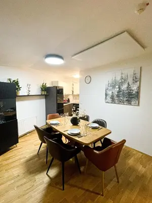 a dining room with a wooden table and chairs at Apartma Pohorske terase Brumen Mariborsko Pohorje in Pohorje