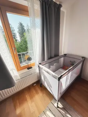 a baby crib in a room with a window at Apartma Pohorske terase Brumen Mariborsko Pohorje in Pohorje