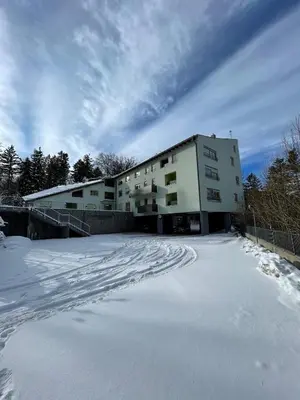 a building with a lot of snow in front of it at Apartma Pohorske terase Brumen Mariborsko Pohorje in Pohorje