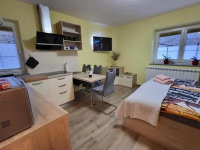 a bedroom with a bed and a desk and a table at Apartma Melita in Kobarid
