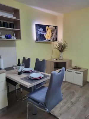 a dining room with a table and a dog poster at Apartma Melita in Kobarid