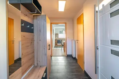 a hallway with a wooden door and a hallway with a kitchen at Alpski škrat, Kranjska Gora in Kranjska Gora