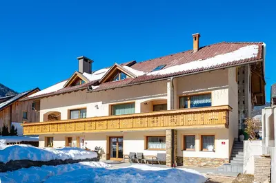 a large building with snow in front of it at Alpski škrat, Kranjska Gora in Kranjska Gora