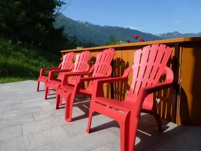 a row of red chairs sitting next to a fence at Apartment Jalps 3 in beautiful Bohinjska Bistrica in Bohinj