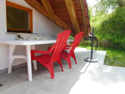 two red chairs and a table on a patio at Apartment Jalps 3 in beautiful Bohinjska Bistrica in Bohinj