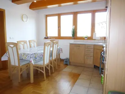 a dining room with a table and chairs and windows at Apartment Jalps 3 in beautiful Bohinjska Bistrica in Bohinj