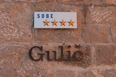 a sign on a brick wall with four stars at G House in Dutovlje