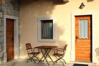 a table and chairs on the side of a house at G House in Dutovlje