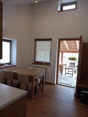 a dining room with a table and chairs and a patio at G House in Dutovlje