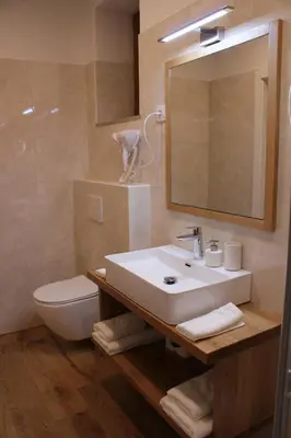 a bathroom with a sink and a toilet and a mirror at G House in Dutovlje