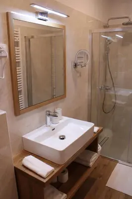 a bathroom with a sink and a shower with a mirror at G House in Dutovlje
