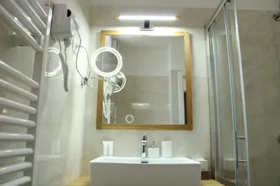 a bathroom with a sink and a mirror and a shower at G House in Dutovlje