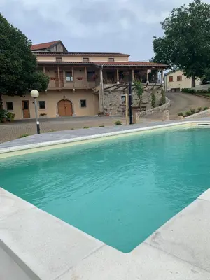 a large blue swimming pool in front of a house at G House in Dutovlje