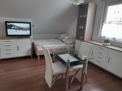 a small room with a dining table and a bed at Apartma Lena in Kranjska Gora