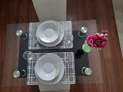 a table with plates and a vase with a flower on it at Apartma Lena in Kranjska Gora