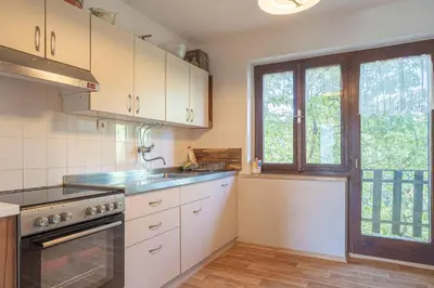 a kitchen with white cabinets and a large window at Holiday home in Loka pri Zusmu Stajerska Untersteiermark 26086 in Loka pri Žusmu