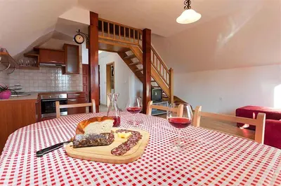 a table with a plate of food and two glasses of wine at Holiday home in Otocec Kranjska Krain 26062 in Otočec