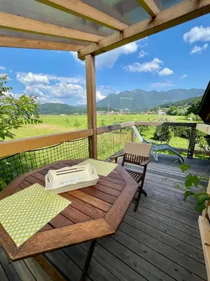 a table and chairs on a wooden deck with a view at Mini Loft close to Logar Valley in Rečica ob Savinji