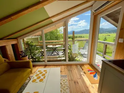 a living room with a large window with a view at Mini Loft close to Logar Valley in Rečica ob Savinji