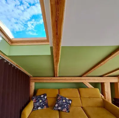 a couch sitting in a room with a window at Mini Loft close to Logar Valley in Rečica ob Savinji