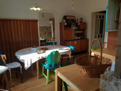 a dining room with a table and chairs in a room at HIŠA VELIKANKA_Giantess in Kostel
