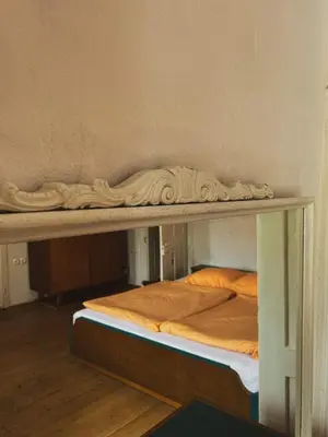 a table with two beds on it in a room at HIŠA VELIKANKA_Giantess in Kostel
