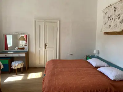 a bedroom with a bed and a desk and a mirror at HIŠA VELIKANKA_Giantess in Kostel