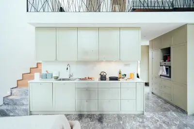 a kitchen with white cabinets and a staircase at Holiday House BALE, BALE in Kostel
