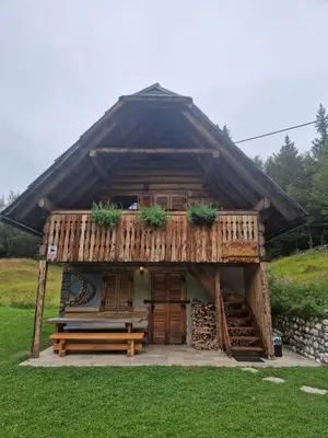 a large wooden building with a bench in the grass at Apartment in Chalet Goldilocks in Zgornje Gorje