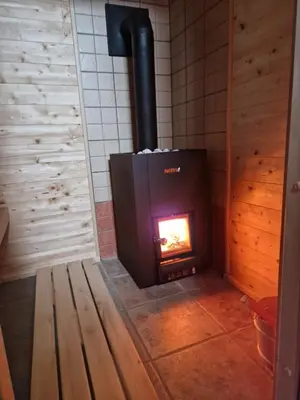 a wood stove in a room with a brick wall at Apartment in Chalet Goldilocks in Zgornje Gorje