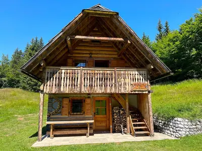 a small log cabin with a porch and a bench at Apartment in Chalet Goldilocks in Zgornje Gorje