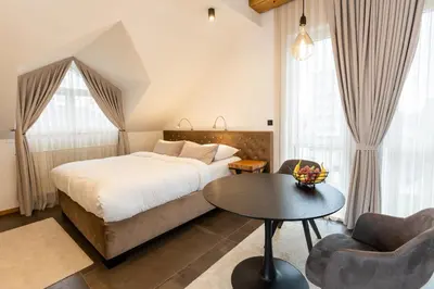 a bedroom with a bed and a table and chairs at Kavenija apartmaji - Free Parking in Maribor