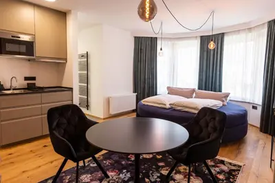 a living room with a couch and a table and chairs at Kavenija apartmaji - Free Parking in Maribor