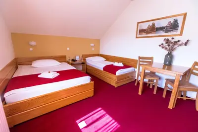 a hotel room with two beds and a desk at B&B Bau in Maribor