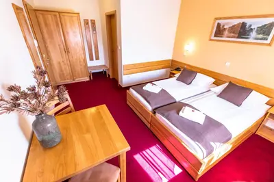 a hotel room with two beds and a table at B&B Bau in Maribor