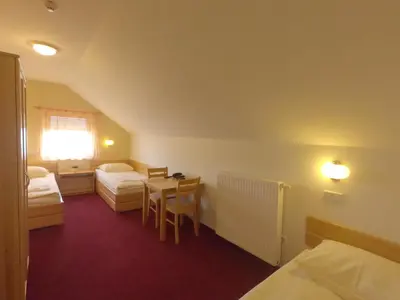 a hotel room with two beds and a table and a tableablish at B&B Bau in Maribor