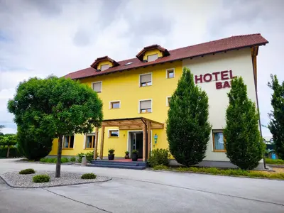 a yellow hotel with trees in front of it at B&B Bau in Maribor