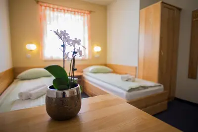a room with two beds and a vase on a table at B&B Bau in Maribor