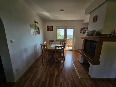 a dining room with a table and chairs and a fireplace at zidanica Bunderšek in Šentjanž