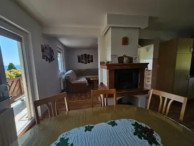 a kitchen and living room with a table and chairs at zidanica Bunderšek in Šentjanž