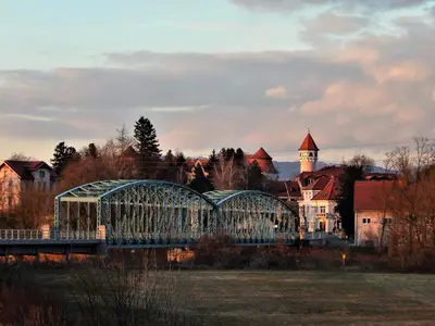 a bridge over a river with a building in the background at Guesthouse Pr'Šefu in Brežice