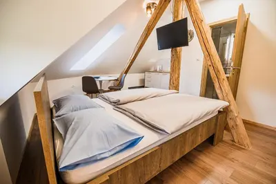 a bed with a wooden frame in a room at Guesthouse Pr'Šefu in Brežice