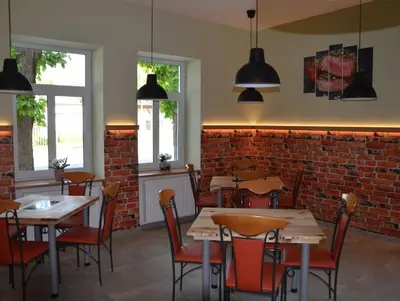 a restaurant with tables and chairs and a brick wall at Guesthouse Pr'Šefu in Brežice