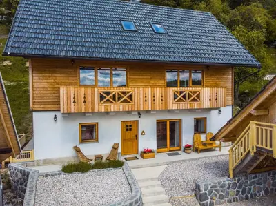 a house with a metal roof and a deck at A house with the view in Srednja Vas v Bohinju