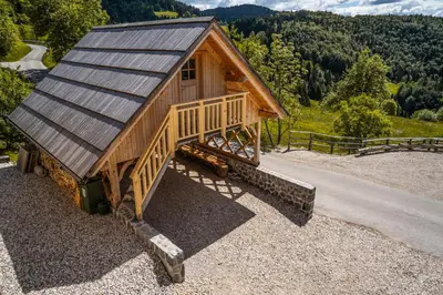 a cabin with a metal roof on top of gravel at A house with the view in Srednja Vas v Bohinju