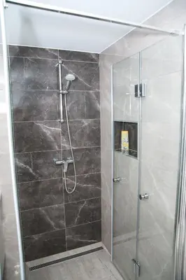 a shower with a glass door in a bathroom at Apartma Lara in Lesično